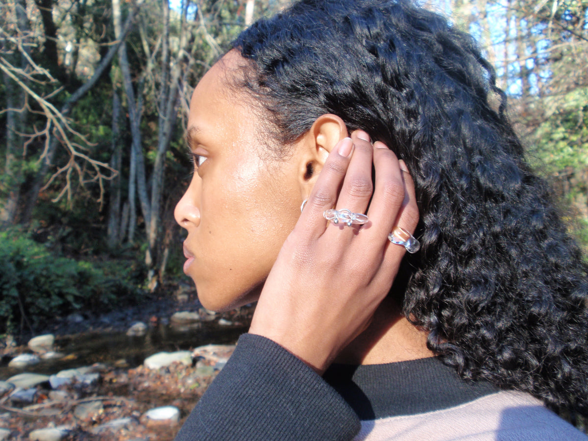 Brutalist Pierced Glass Ring 0117 in hand-sculpted borosilicate glass, worn, outdoor portrait, Rain and Rivers