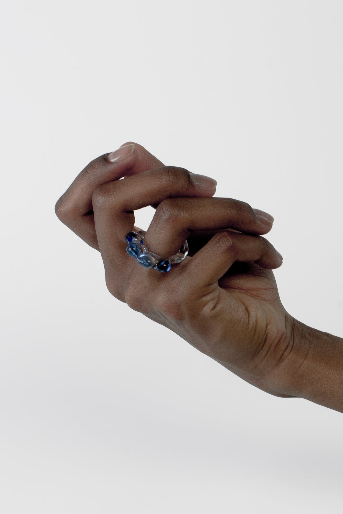 Soft Organic Glass Ring 0105 in clear and sky blue worn on the hand, hand-sculpted borosilicate glass by Rain and Rivers, Barcelona
