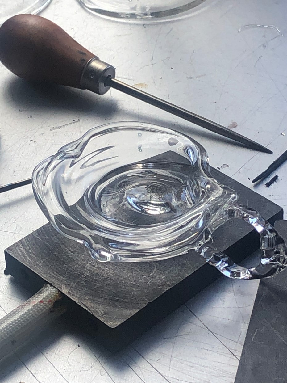 Ashtray 0001 in clear hand-sculpted borosilicate glass, in the studio, Rain and Rivers