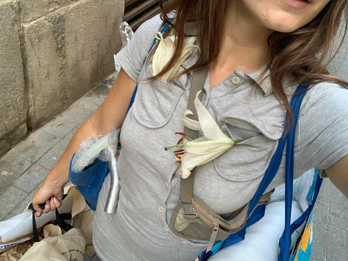 Magdalena Hart wearing a glass sculpture with a white lily, wearable glass by Rain and Rivers