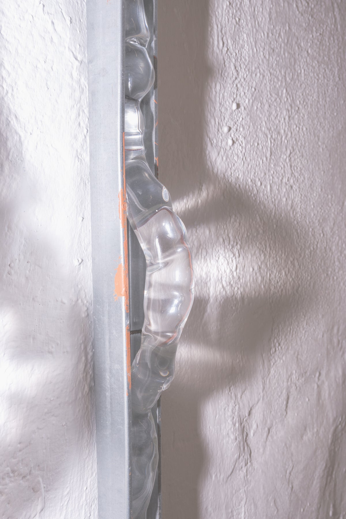 Detail of textured blown glass against a steel rail